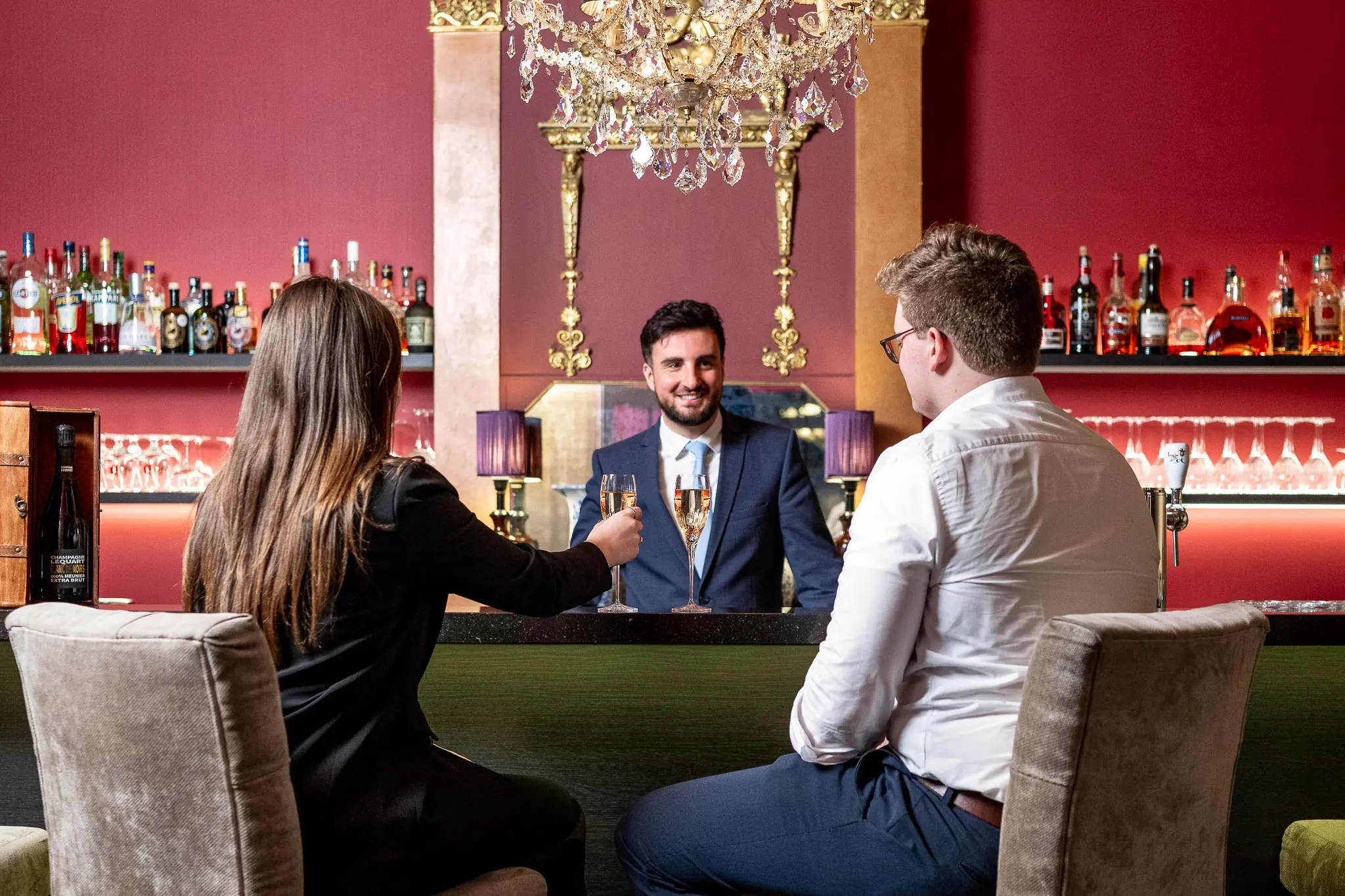Guests drinking champagne in the bar of Hotel de Castillion