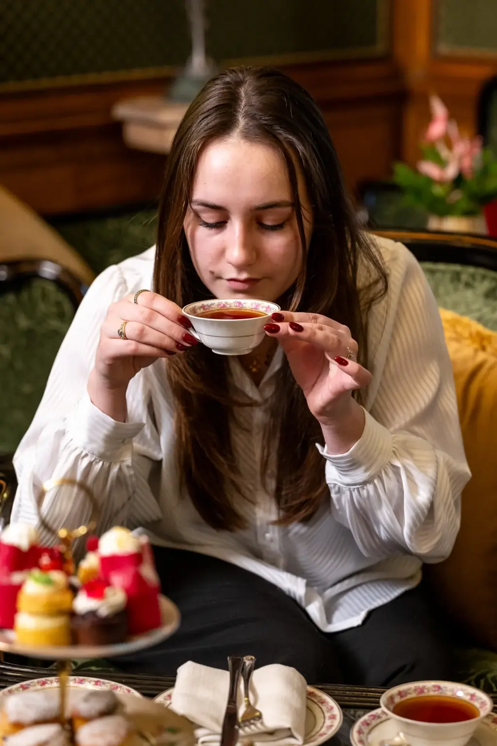 Een gast drinkt thee tijdens de afternoon tea in Hotel De Castillion
