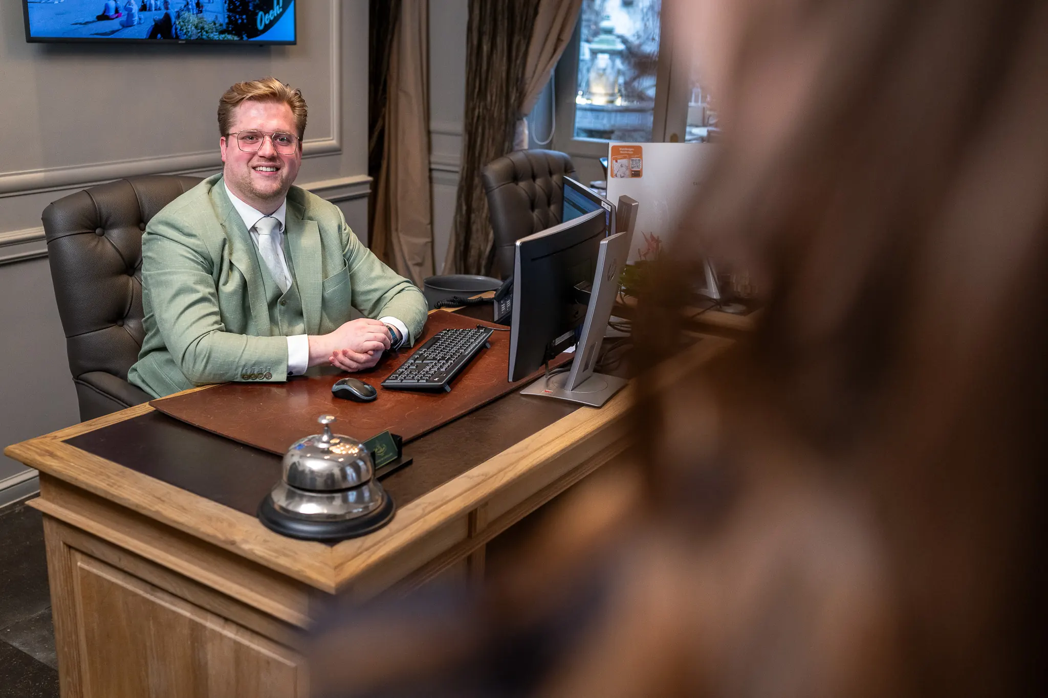 Een van de eigenaren van Hotel de Castillion bij de incheckbalie